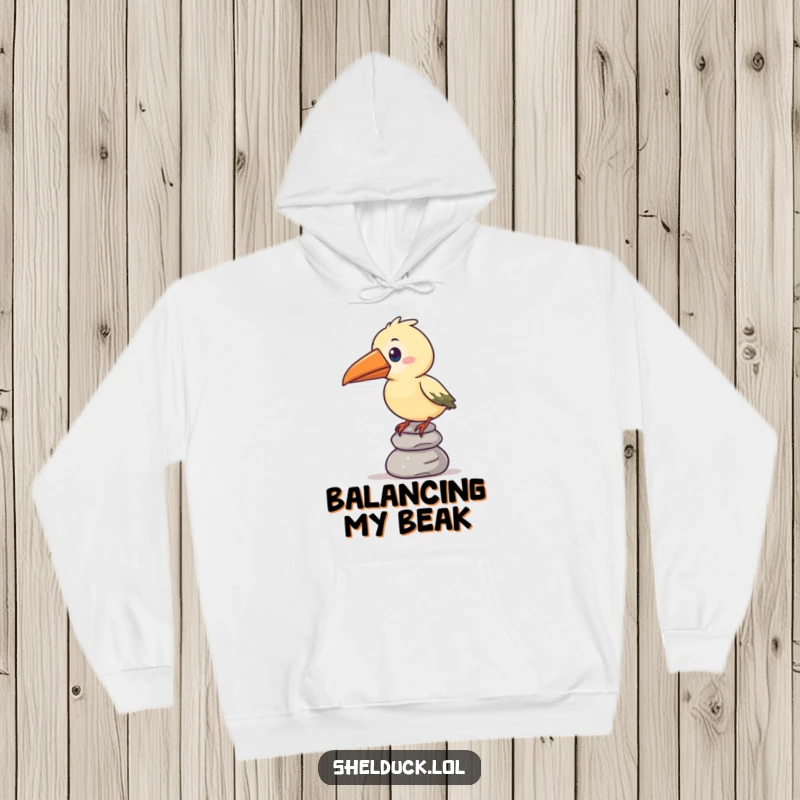 Funny hoodie showcasing a stylized bird with an oversized beak humorously balancing a stack of pebbles, radiating comic effort.