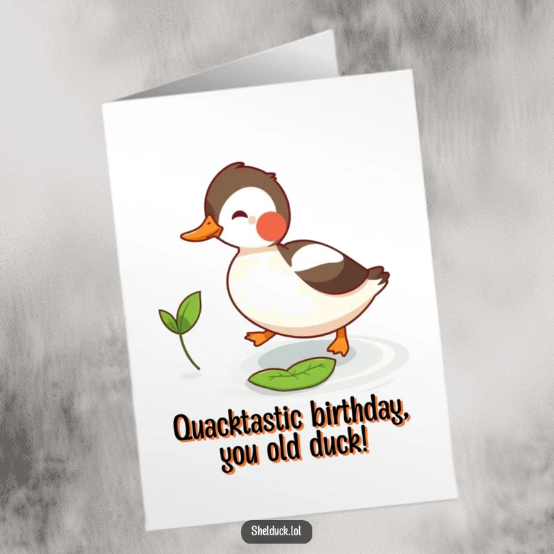 Funny Free Printable Birthday Card featuring a joyful shelduck playfully chasing a tiny floating leaf on a blue background.