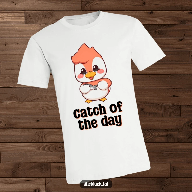 Funny shelduck t-shirt with a cheerful bird holding a small fish, perfect for fishing trips and casual wear.
