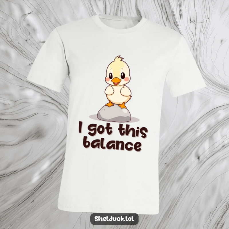 Funny Shelduck T-Shirt: A shelduck is comically depicted trying to balance a tiny pebble, embodying playful struggle.